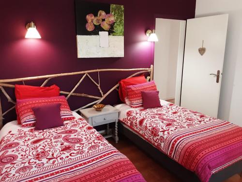 two beds in a room with purple walls at La Bonbonne en Provence in Travaillan