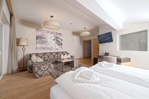 a hotel room with two beds and a couch at Ortnerhof - Ihr Zuhause am Fuße der Alpen in Ruhpolding