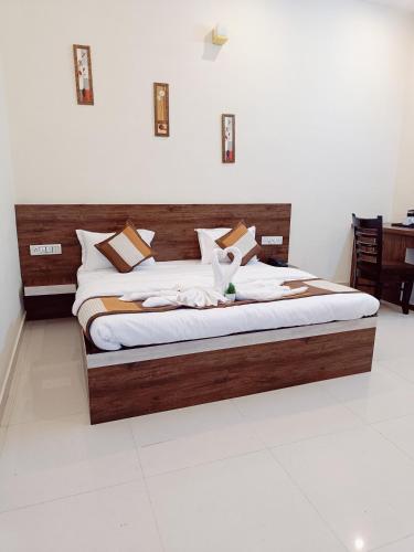 a bed in a room with a wooden headboard at Green Club Farm in Ajmer