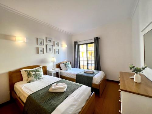 Habitación de hotel con 2 camas y ventana en Vilamoura Paradise With Pool by Homing, en Vilamoura