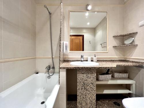 y baño con bañera, lavabo y espejo. en Vilamoura Paradise With Pool by Homing, en Vilamoura