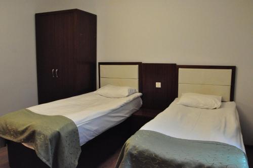 two beds sitting next to each other in a room at Vilesh Palace Hotel in Masallı
