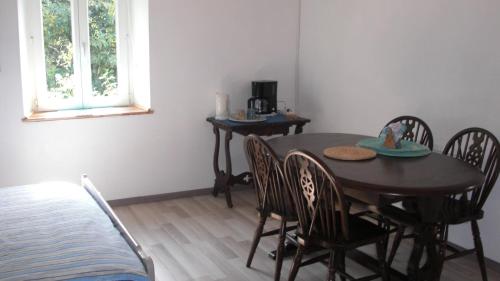 a dining room with a wooden table and chairs at Captains Cabin, gite neuf dans ancienne maison campagne in Saint-Priest-la-Plaine