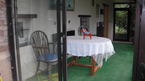 a table with a white table cloth and chairs at Captains Cabin, gite neuf dans ancienne maison campagne in Saint-Priest-la-Plaine