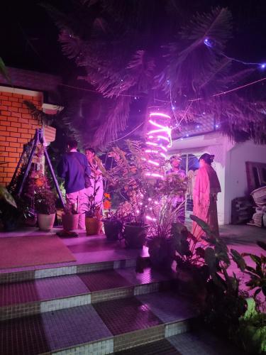 a group of people standing on a porch at night at Rupali Tat Ghar and Homestay in Majuli