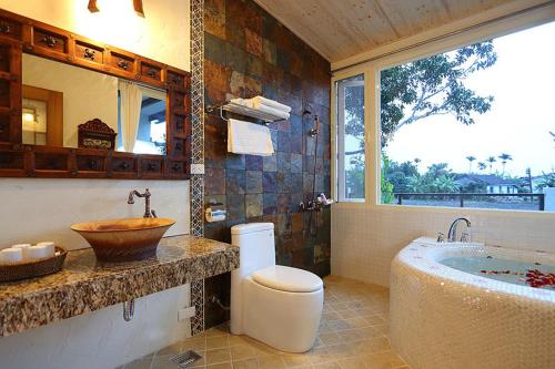 a bathroom with a tub and a toilet and a sink at Cloudenjoy B&B in Hualien City