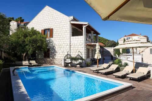 a swimming pool in front of a house at Villa Peragro in Dubrovnik