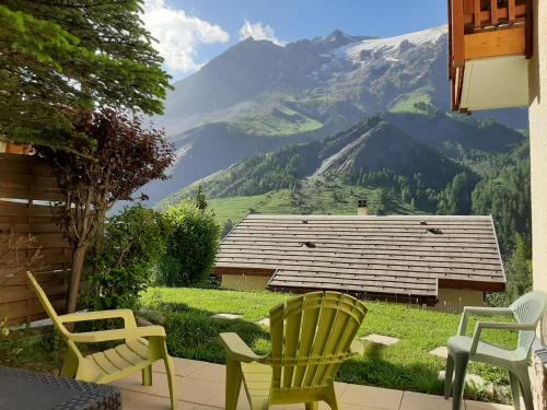 a patio with chairs and a view of a mountain at Panoramic Village - Locations vue Glaciers - Chez Philippe in La Grave