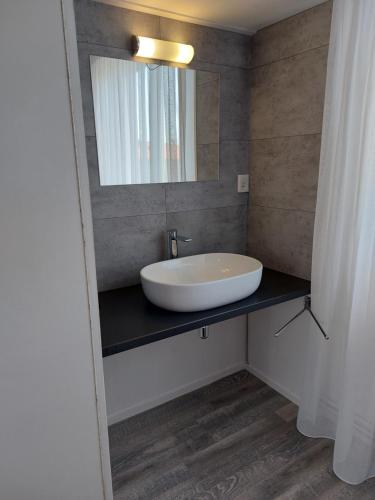 a bathroom with a sink and a mirror at Appartement met 3 slaapkamers vlakbij strand en centrum in Zoutelande