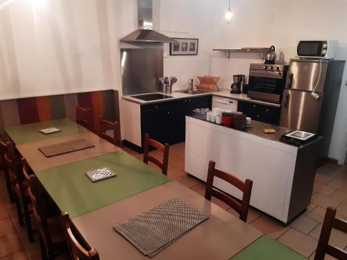 a kitchen with a table and a kitchen with a refrigerator at La Cazalère in Campan