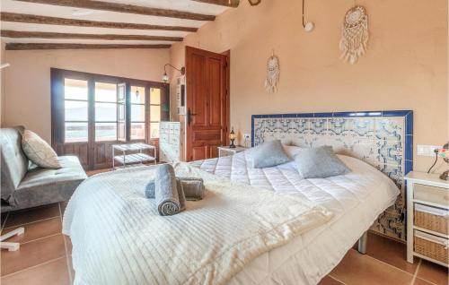 een slaapkamer met een groot bed en een stoel bij Awesome Home In El Poleo With Outdoor Swimming Pool in Las Higueras