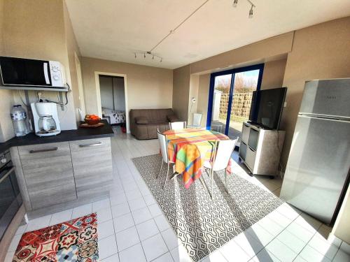 Il comprend une cuisine avec une table et des chaises. dans l'établissement LA MER A VOS PIEDS, à La Forêt-Fouesnant