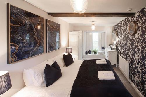 um quarto com uma grande cama branca e um sofá em Fleece Cottage em Kendal