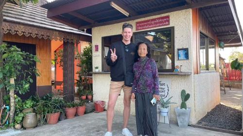 a man and a woman standing in front of a building at Rim Than View Resort in Ubon Ratchathani