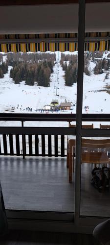 una ventana con vistas a un campo cubierto de nieve en Aux pieds des pistes refait à neuf en Superdevoluy