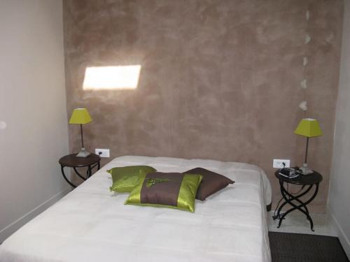 1 dormitorio con 1 cama blanca grande y 2 lámparas en Le Maset des Aires avec vue sur le Luberon et son jacuzzi extérieur disponible de juin à mi-septembre, en Maubec