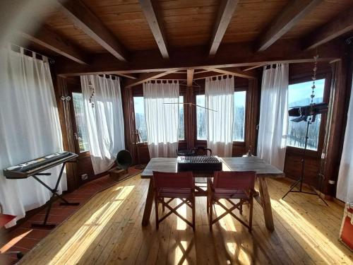 a dining room with a table and chairs and windows at Azienda Agricola Il Querceto in Marsico Vetere
