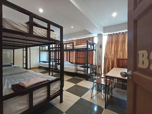 a room with three bunk beds and a table at Studio'Z in Chiang Mai