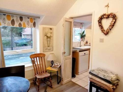 a kitchen with a table and a heart hanging on the wall at Bright modern apartment, Shipston-on-Stour in Honington