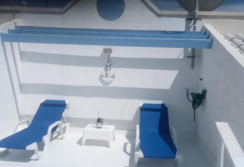 Pokój typu lego z 2 niebieskimi krzesłami i umywalką w obiekcie Duquesa Beach w mieście Torrevieja