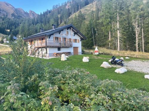 a house on a hill with rocks in front of it at Chalet Paradisi in Castello Tesino