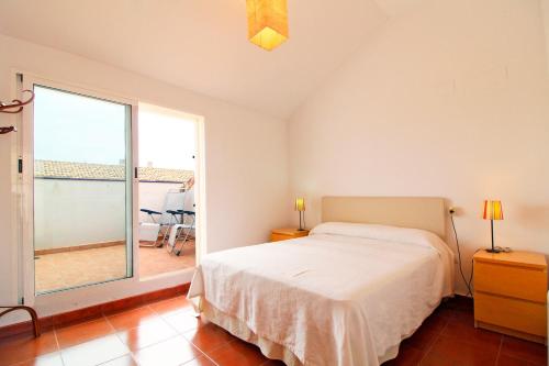 ein Schlafzimmer mit einem Bett und einem großen Fenster in der Unterkunft Global Properties, Apartamento con piscina en playa Corinto in Sagunt