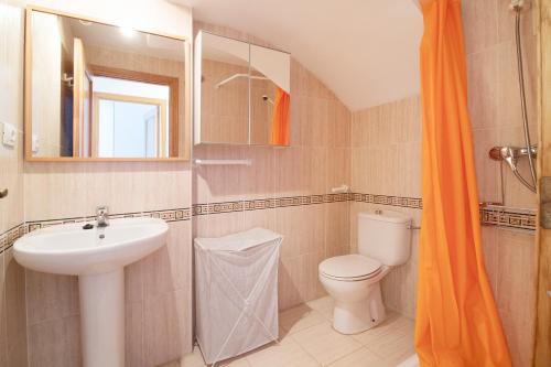 ein Badezimmer mit Waschbecken, Toilette und Spiegel in der Unterkunft Global Properties, Apartamento con piscina en playa Corinto in Sagunt