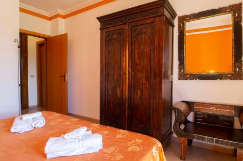 a bedroom with a bed and a wooden cabinet at Hotel Iride by Marino Tourist in San Vito lo Capo