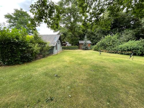 a large yard with a house and a grass field at Luett Huus in Gartow