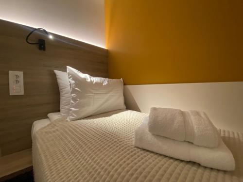 a bed with white sheets and pillows in a room at Konak Stella in Belgrade