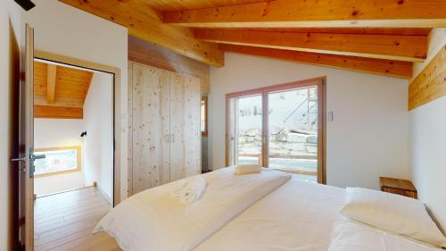 sypialnia z dużym białym łóżkiem i oknem w obiekcie Teddy's VIEW & QUIET chalet 6 pers w mieście Agettes
