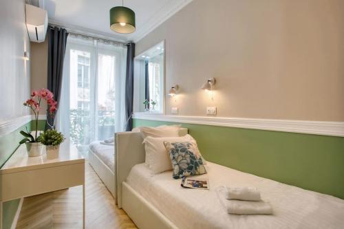 une petite pièce avec un lit et une fenêtre dans l'établissement Chaleureux 100m2 3CH - Séjour Romantique Parfait, à Paris