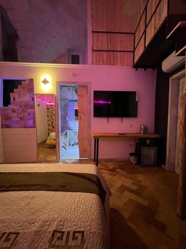 a bedroom with a bed and a tv in a room at The Bridge Suites in Gravina in Puglia