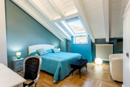 a blue bedroom with a bed and a skylight at MEMA HOLIDAY HOME in Aosta