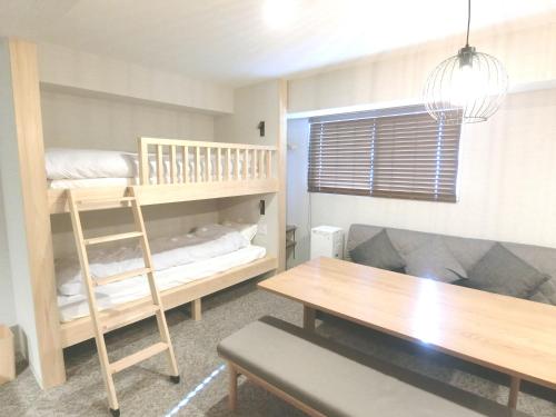 um quarto com um beliche e uma mesa em KLASSO Tokyo Sumiyoshi Apartments em Tóquio