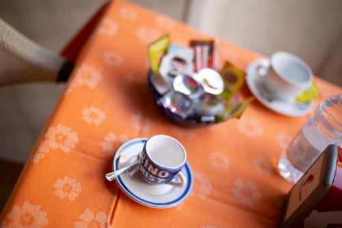 a table with two cups and saucers on it at Hotel Iride by Marino Tourist in San Vito lo Capo