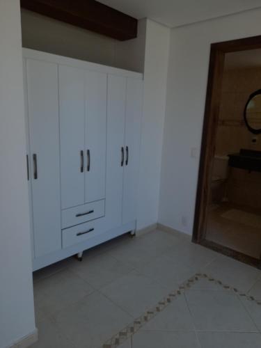 a room with white cabinets and a mirror at Casa da Praia in Itajaí