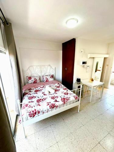 a bedroom with a white bed with red pillows at Central Comfort Studio in Larnaka