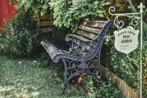 a bench sitting in the grass next to a bush at La Borie du Chevrier in Sainte-Croix-de-Beaumont