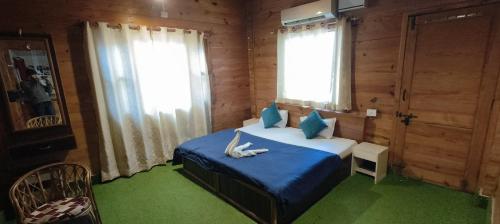sypialnia z łóżkiem z niebieską pościelą i niebieskimi poduszkami w obiekcie BlueStays Hostel w mieście Rishikesh