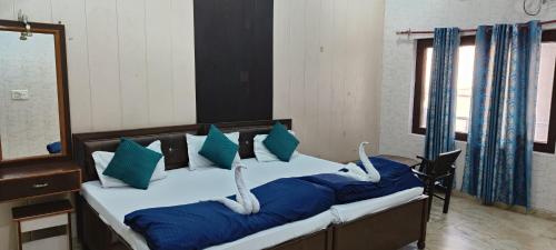 a bedroom with two beds with blue and white pillows at BlueStays Hostel in Rishīkesh