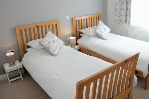 two twin beds in a room with two lamps at Seafront House, Westward Ho! in Westward Ho