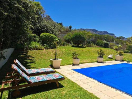 una piscina con un sillón junto a una piscina en Villa with exquisite mountain and sea views…, en Ciudad del Cabo