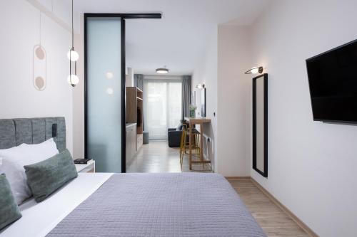 a bedroom with a bed and a flat screen tv at Enattica Suites in Athens