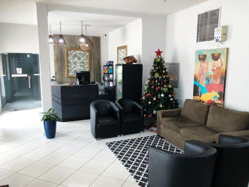 - un salon avec un arbre de Noël et un canapé dans l'établissement Hotel Ceolatto, à Várzea Grande