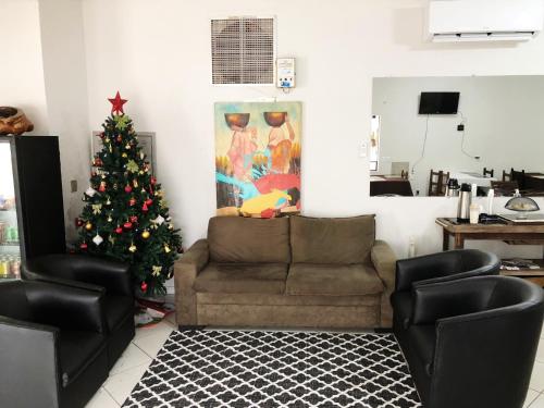 uma sala de estar com uma árvore de Natal e um sofá em Hotel Ceolatto em Várzea Grande