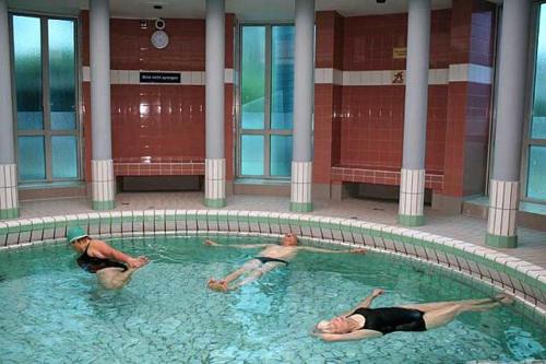 three people in a swimming pool in a building at Luett Huus in Gartow