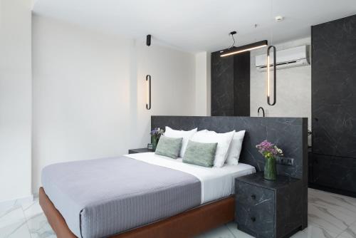 a bedroom with a large bed with white sheets and green pillows at Enattica Suites in Athens