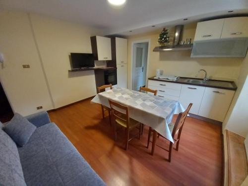 ein Wohnzimmer mit einem Tisch und einer Küche in der Unterkunft Appartamento Sophie LT in Santa Maria Maggiore