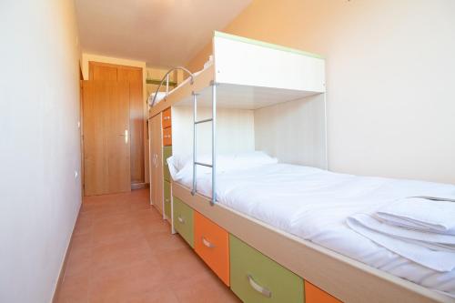 a bedroom with a bunk bed with a ladder at Global Properties, Apartamento en Marjal de Corinto con Piscina in Sagunto